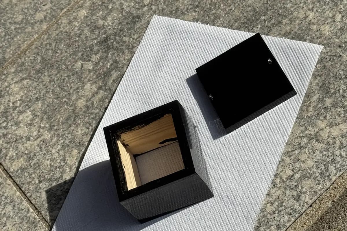 cube shell painted black, drying outdoors