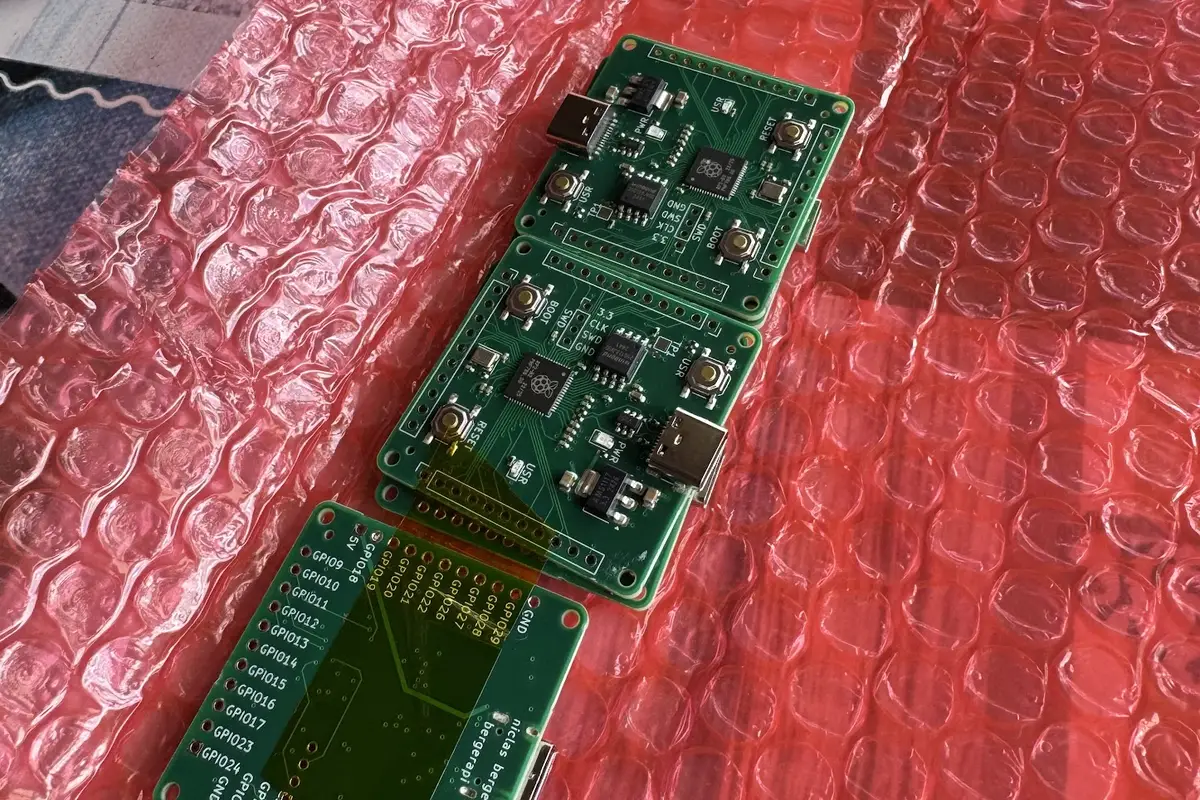 three assembled rp2040 dev boards on pink bubble wrap